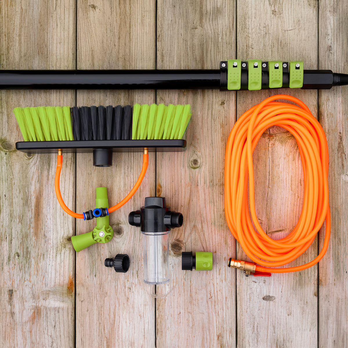 Éléments de la brosse de lavage : manche télescopique, tête de brosse, tuyau orange, distributeur de savon et raccords