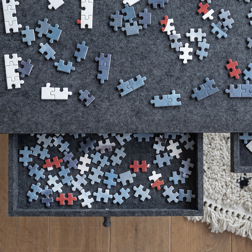 Close-up van een uitgeschoven vilten lade met puzzelstukjes